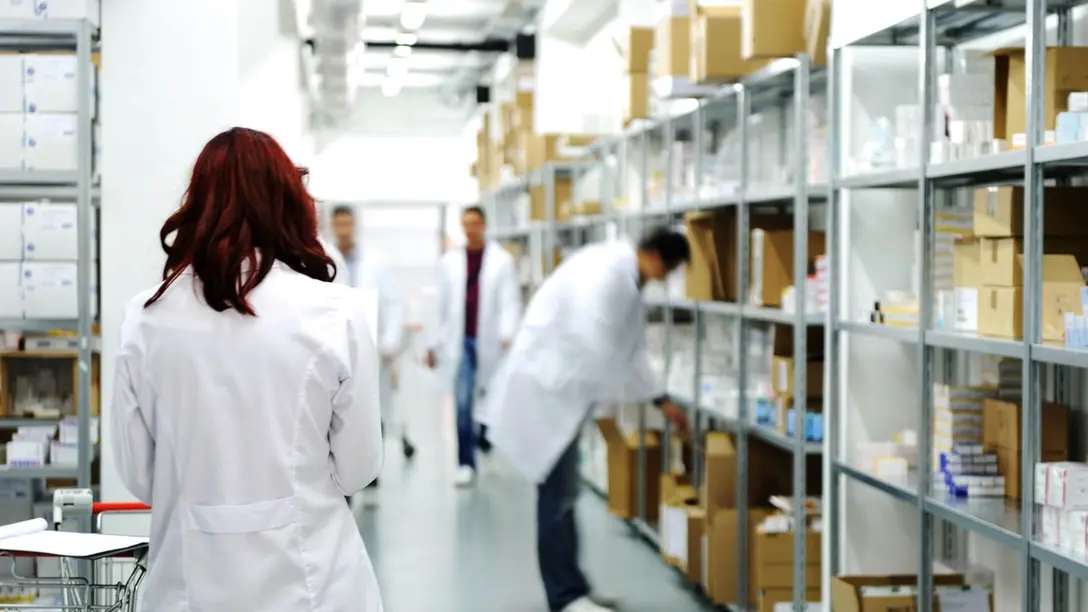 Personen in weißen Kitteln arbeiten in Lagerraum