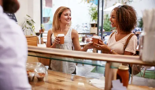 Frauen bestellen Kaffee an der Theke