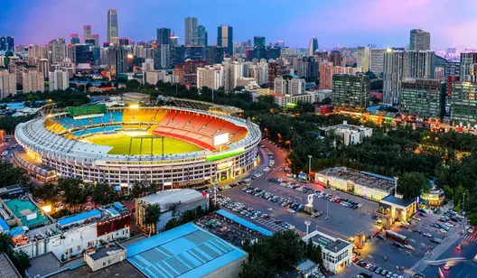 Luftaufnahme von einer Arena mit einer Stadt im Hintergrund