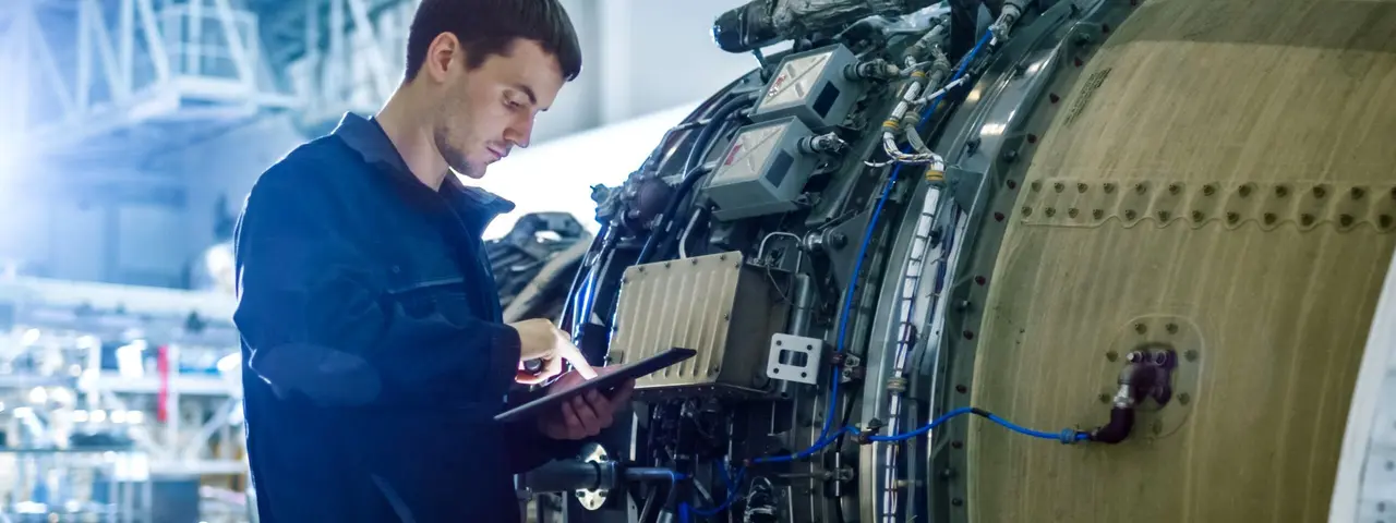 Mann steht neben großer Maschine